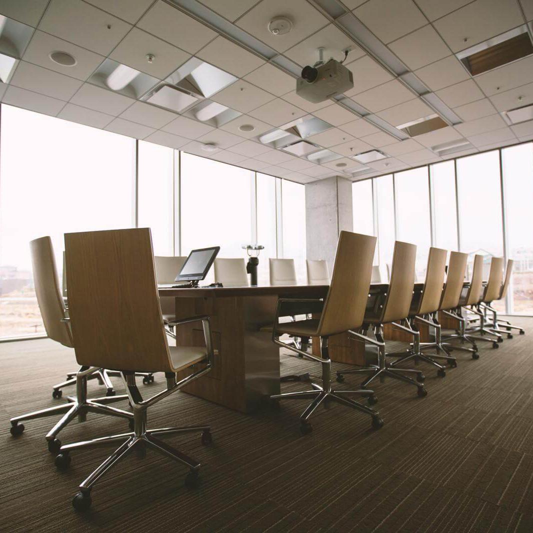 Oval brown wooden conference table and chairs inside conference room